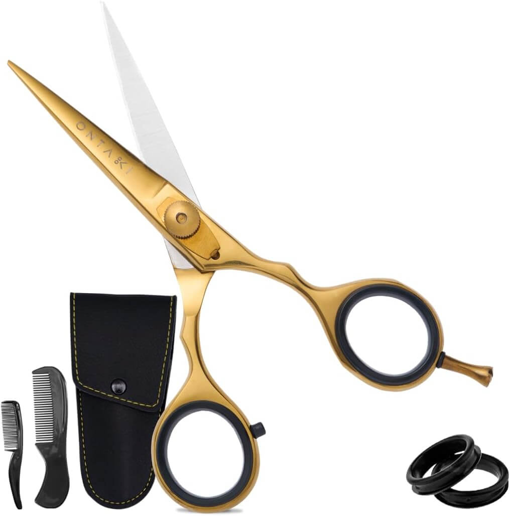 Gold scissors with black handles and a black case on a white background