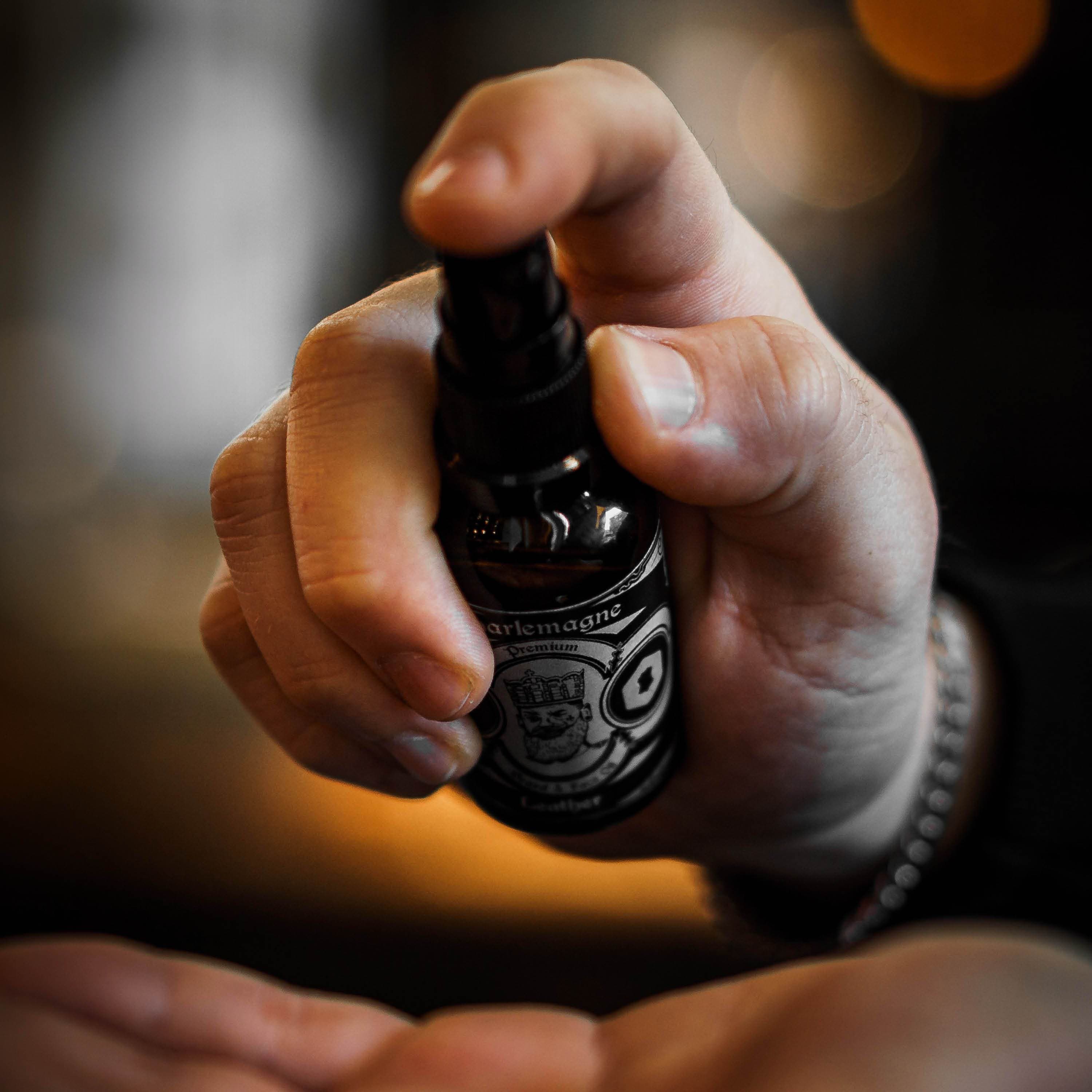 Hand holding a bottle of Premium Beard Oil "Imperial Inheritance" being dispensed into palm.